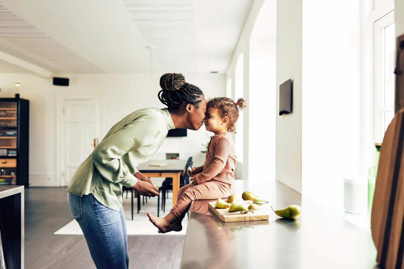 Mom and young child playing in the kitchen.