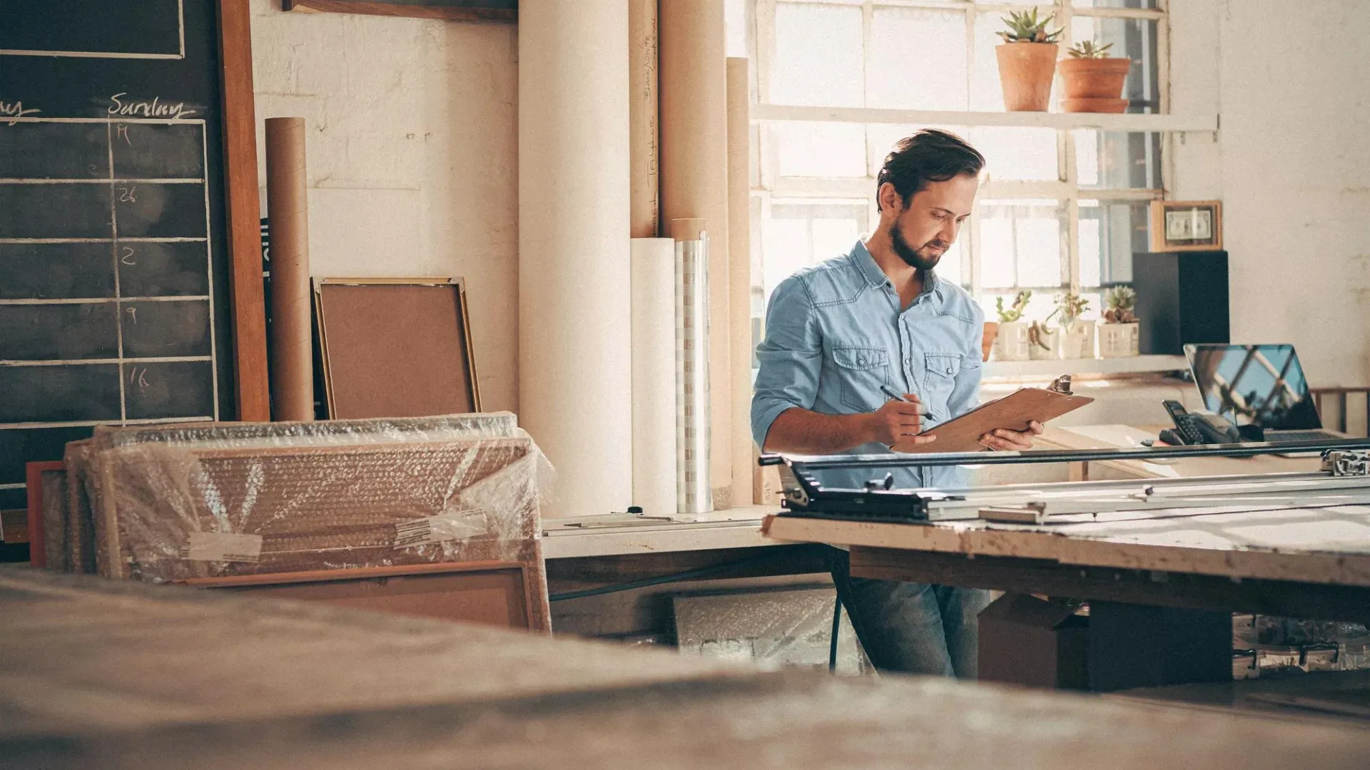 A person working at a wooden desk in a casual office or home workspace environment.